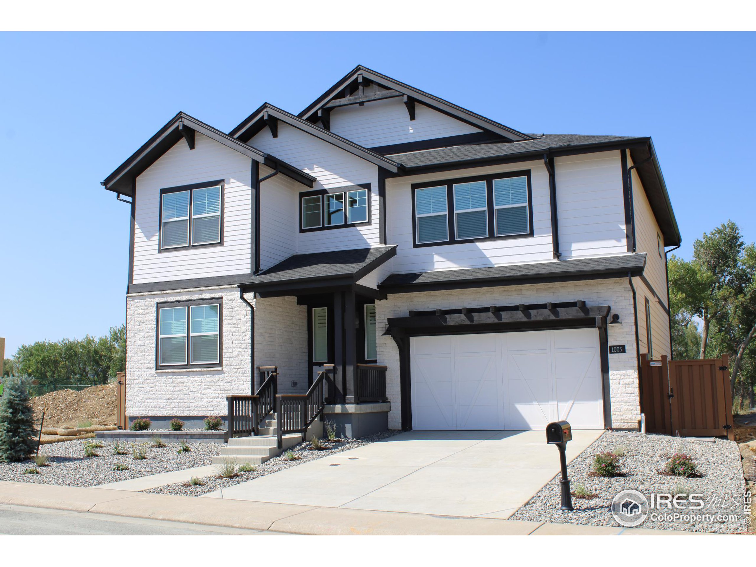 a front view of a house with a yard outdoor seating and garage