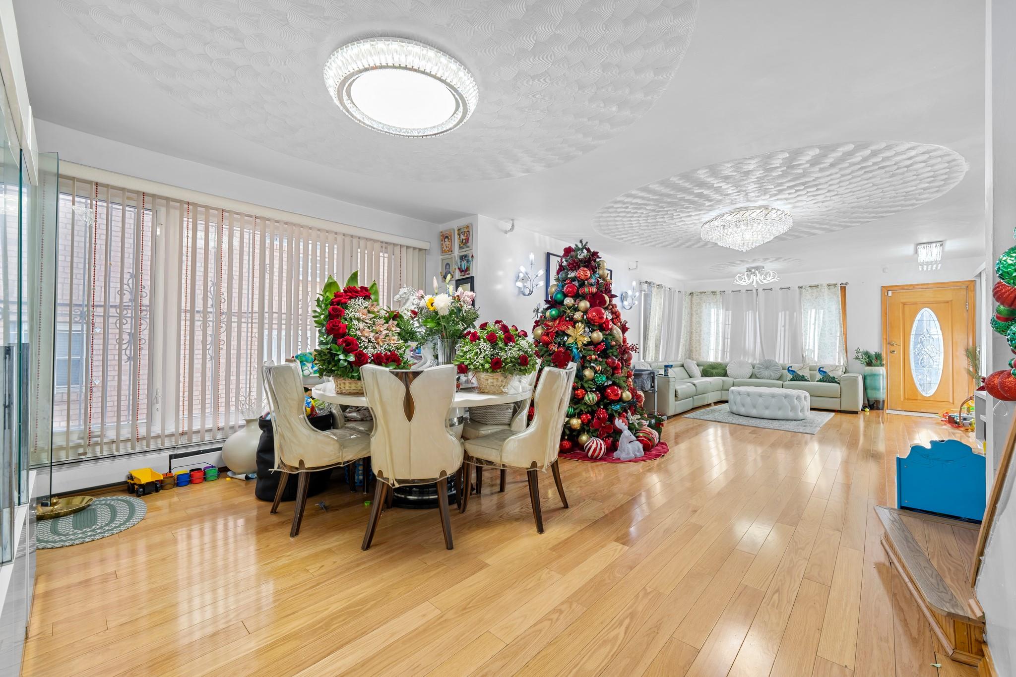 Dining room with a textured ceiling, light wood-type flooring, a baseboard radiator, and a notable chandelier