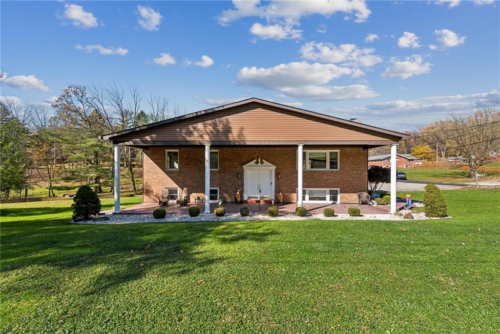 a front view of a house with garden and trees