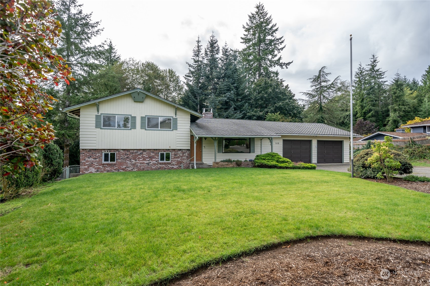 a front view of a house with a garden and yard