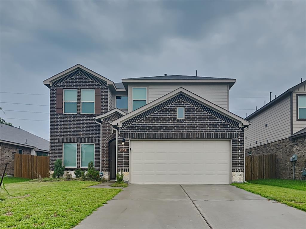 a front view of a house with a yard and garage