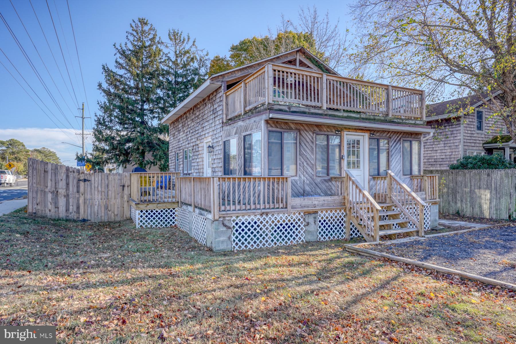 a view of a wooden house with a small yard and wooden fence