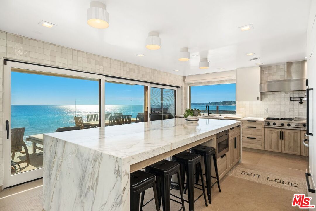 a large kitchen with kitchen island a sink stainless steel appliances and cabinets