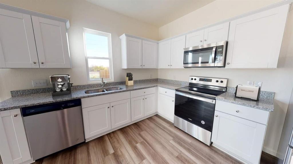 a kitchen with cabinets appliances a sink and a window