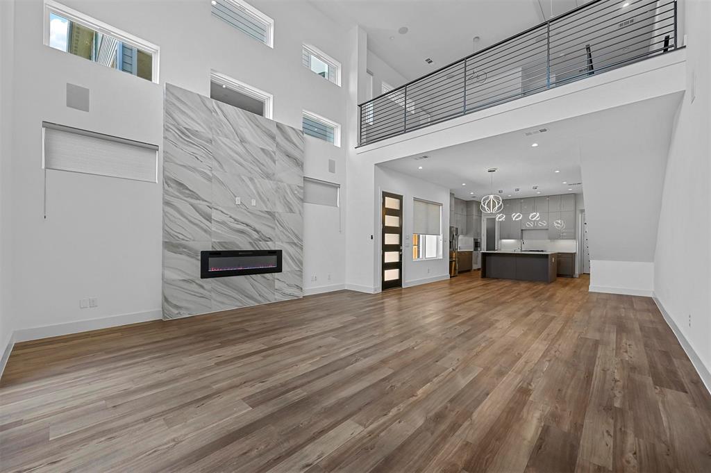 a view of empty room with wooden floor and fireplace