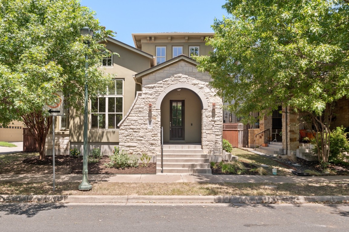 a view of a brick house with large windows and a large tree