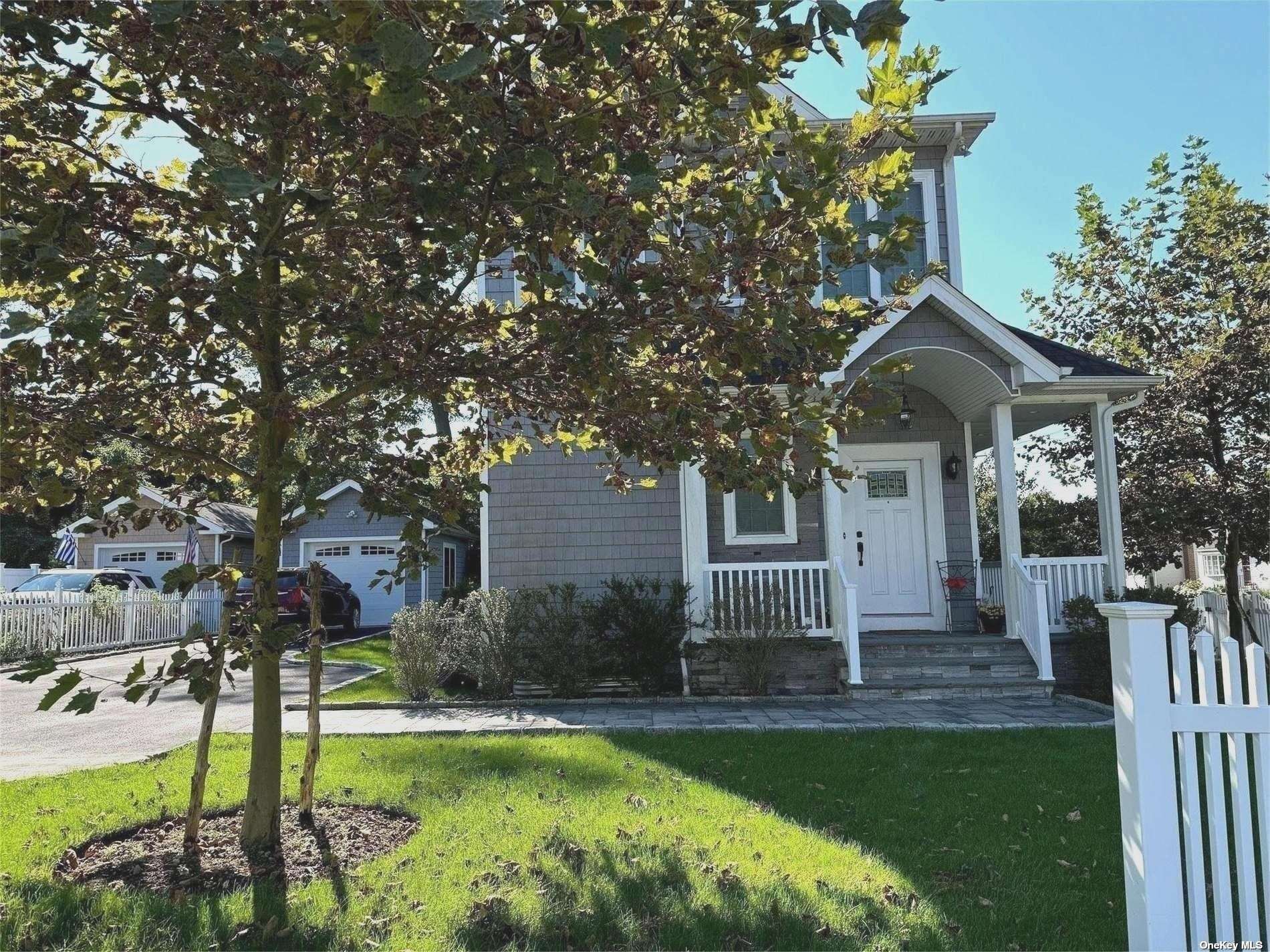 a front view of a house with a garden and trees