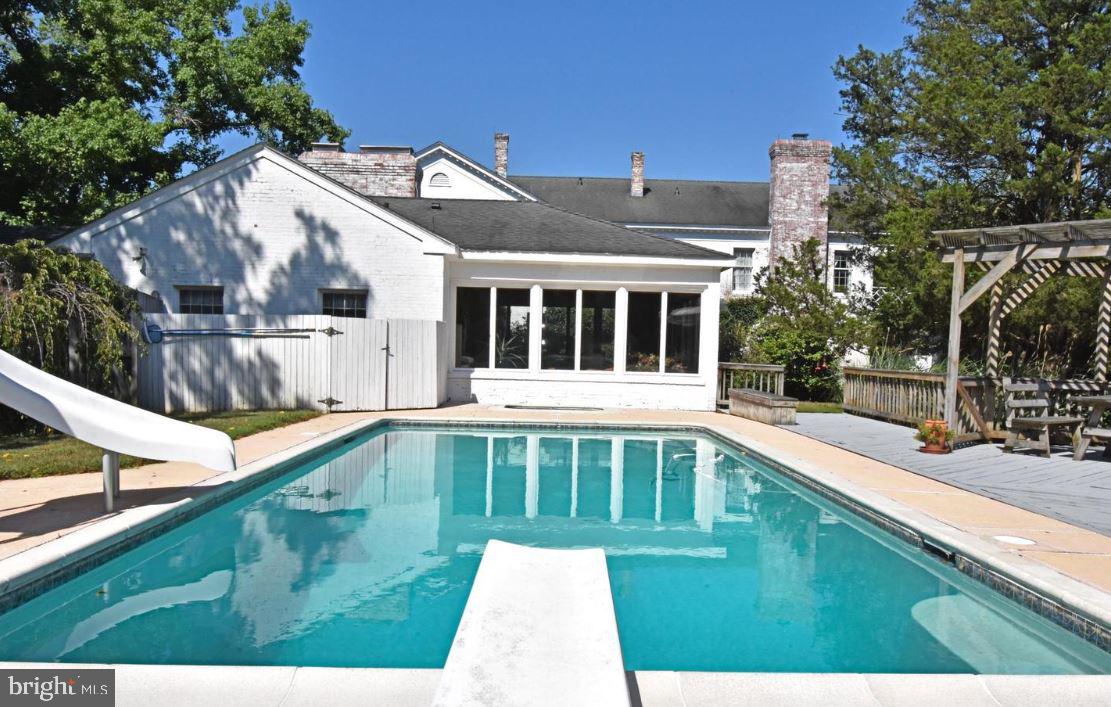 a view of a house with pool and sitting area