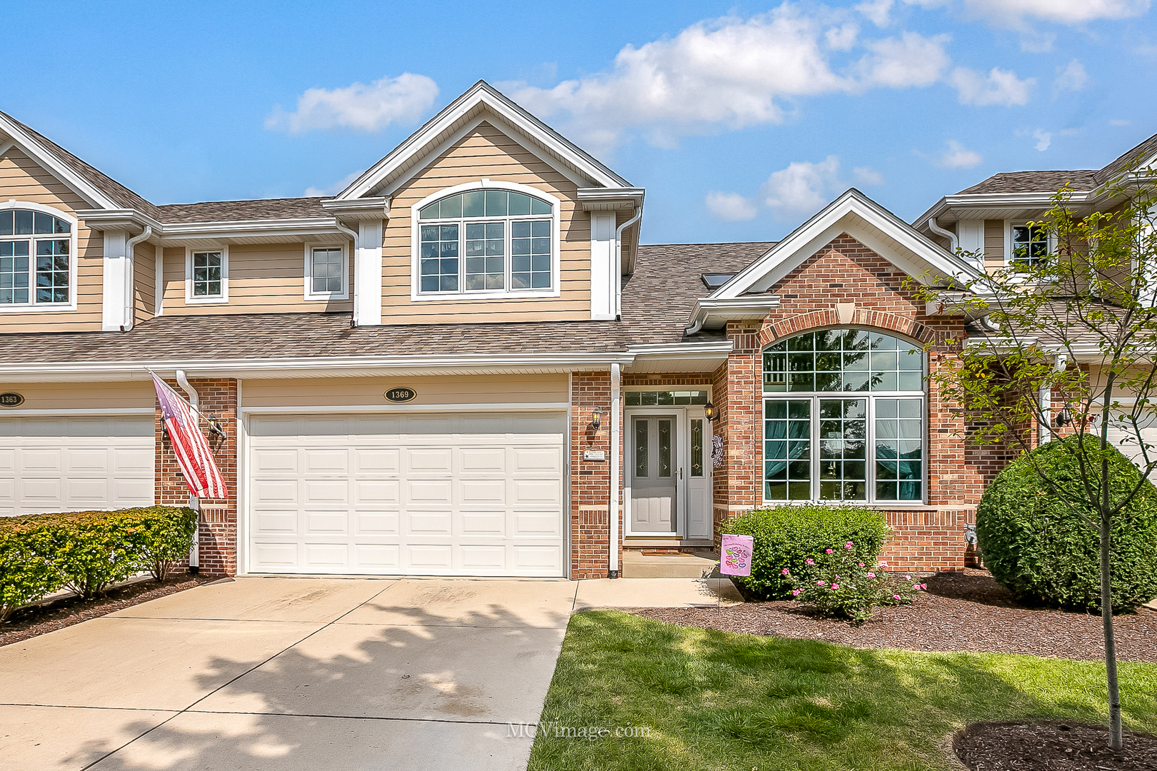 a front view of a house with a yard and garage