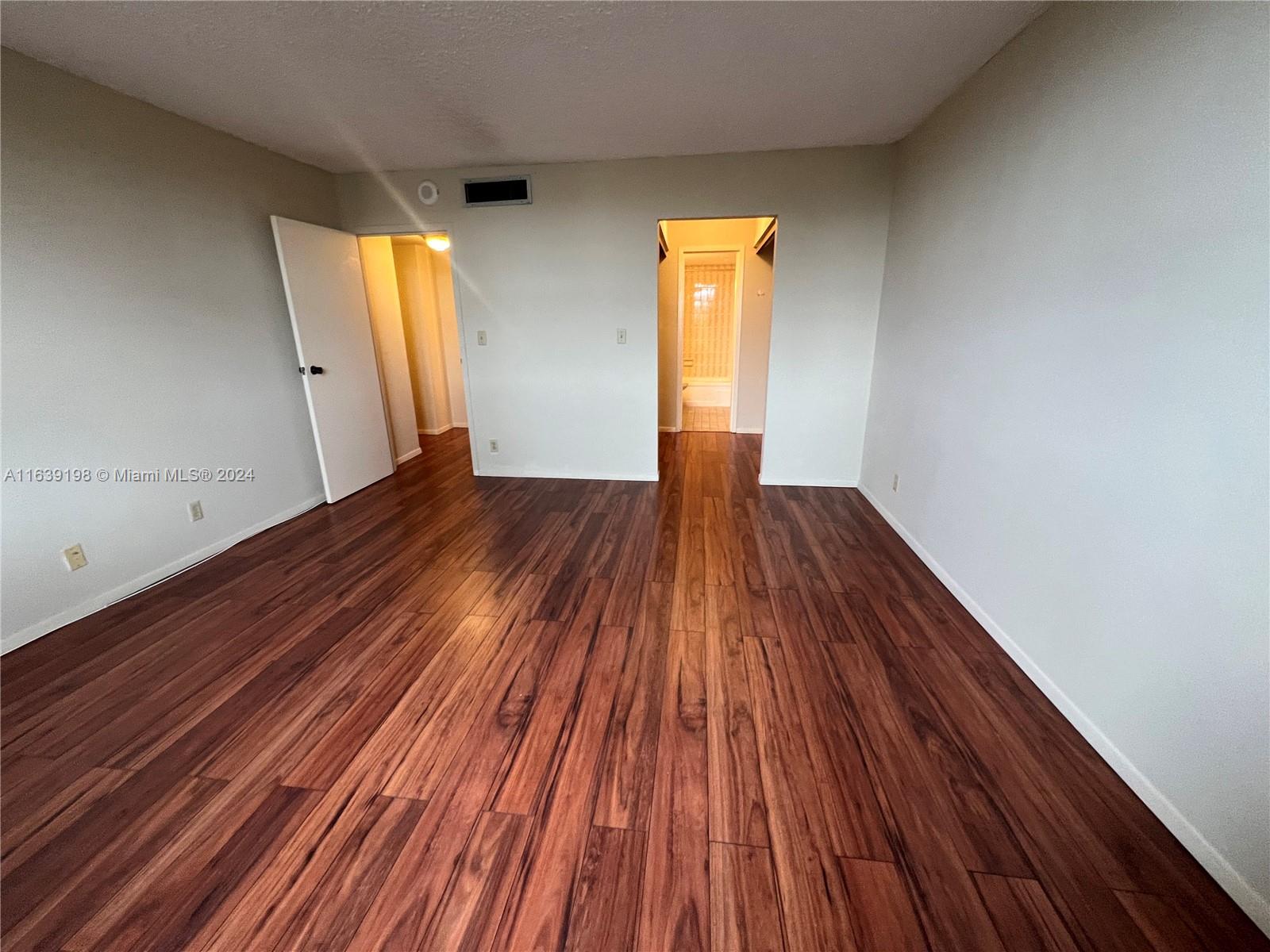 a view of empty room with wooden floor