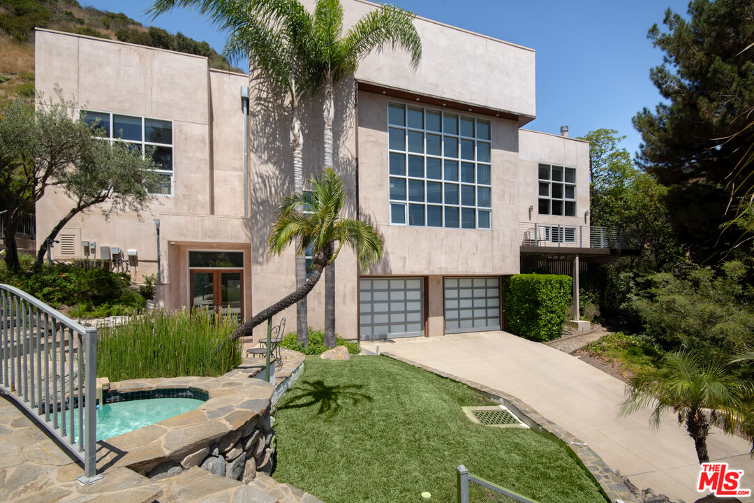 a view of house with a yard and potted plants