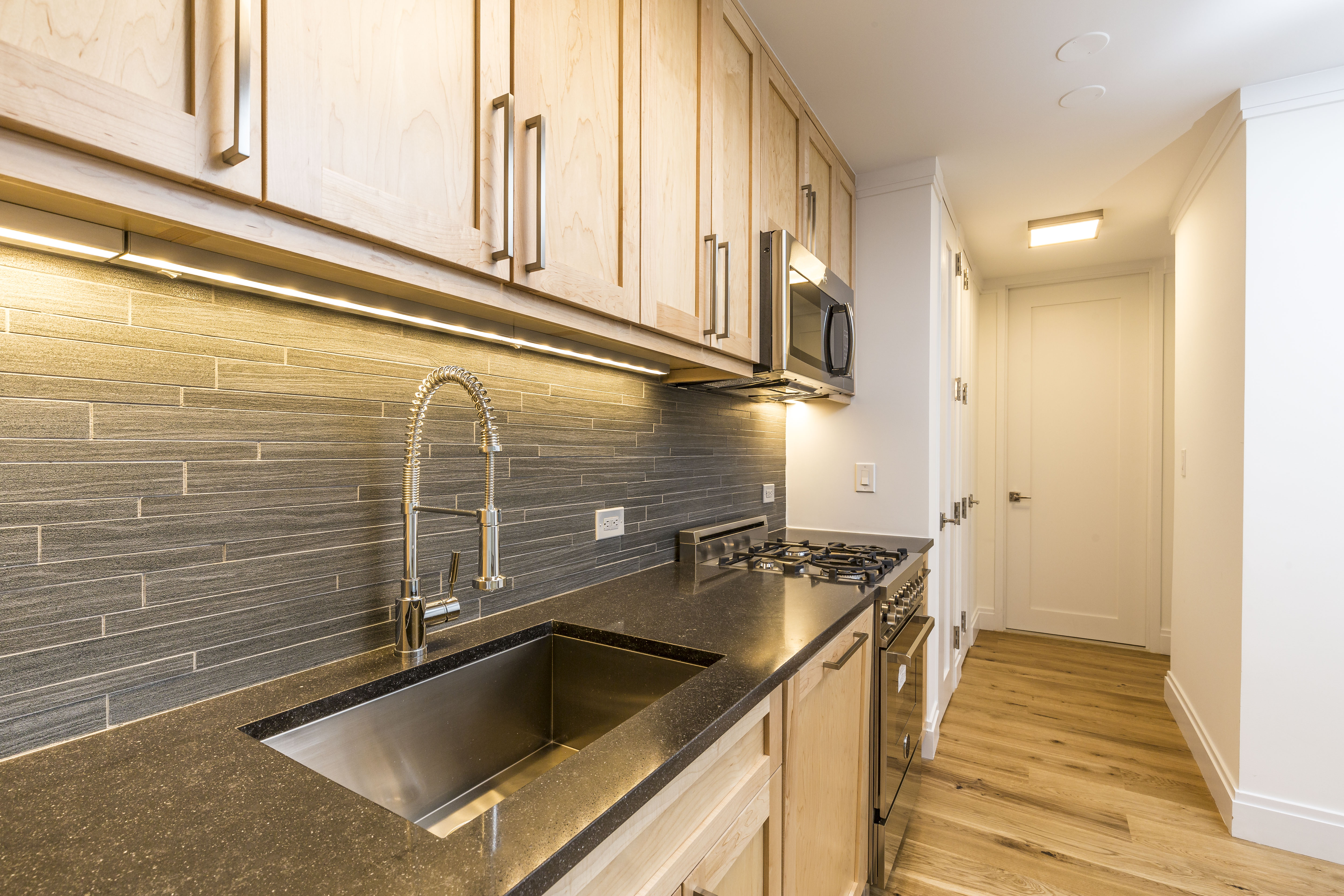 a kitchen with granite countertop a sink and a stove