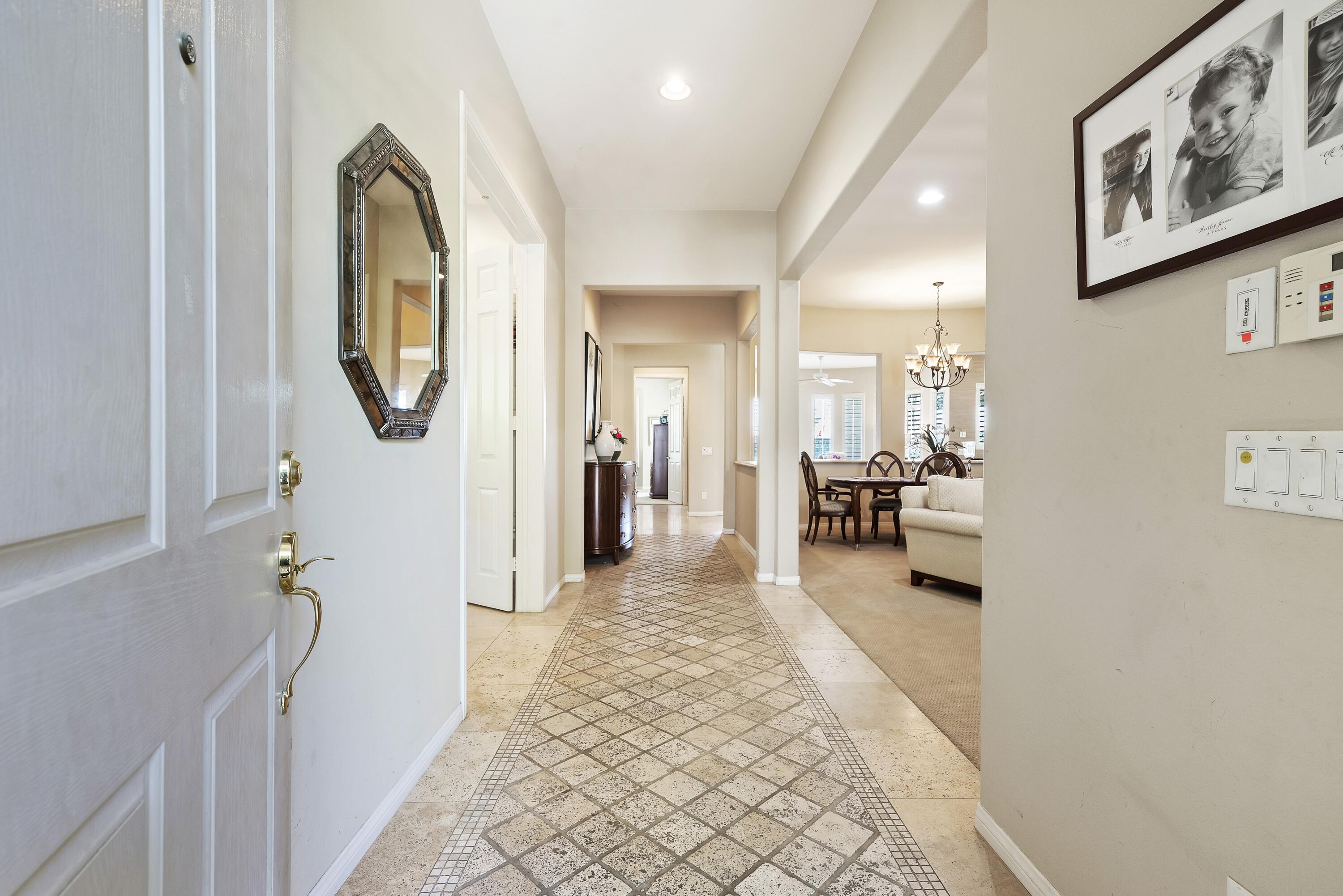 a view of a hallway with furniture and frames on wall