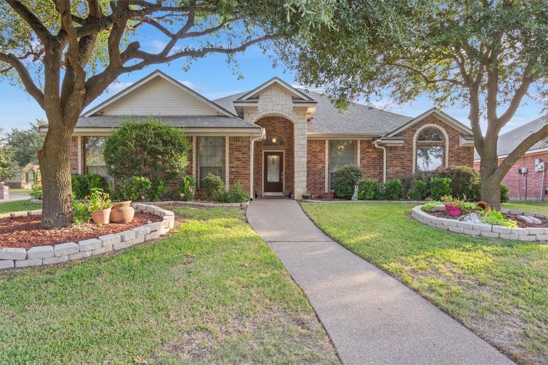 a front view of a house with yard and green space