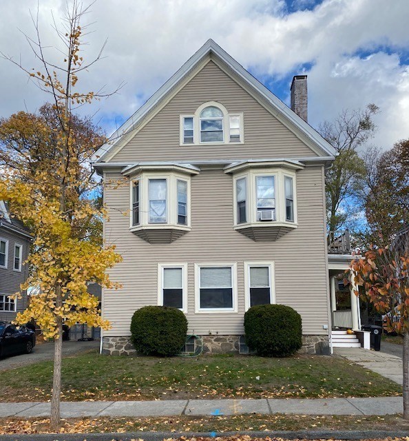 a view of a brick house with a yard and large windows