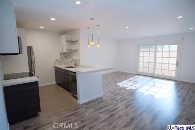 a kitchen with stainless steel appliances granite countertop a sink stove and wooden floor