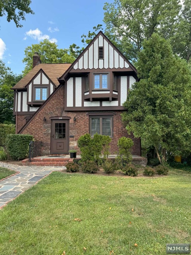 a front view of a house with a yard and trees