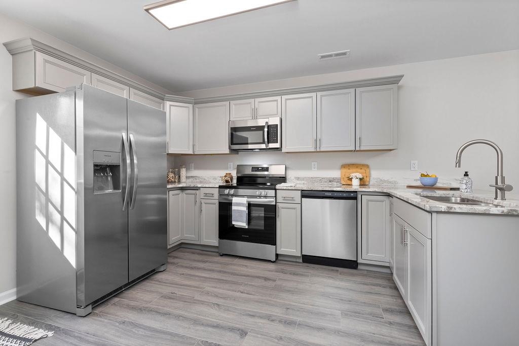 a kitchen with a refrigerator sink and cabinets