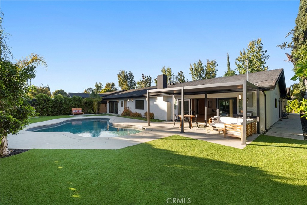 a view of a house with swimming pool and sitting area