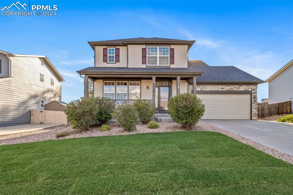 Front of property featuring a front lawn, a porch, and a garage