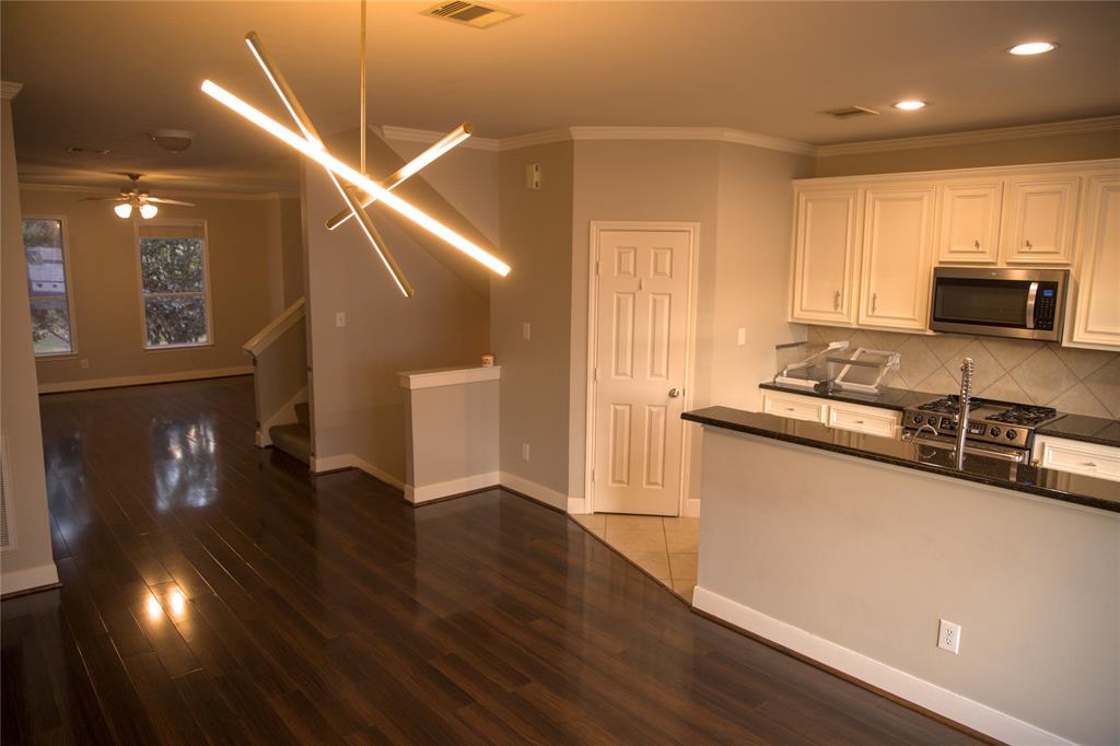 a kitchen with granite countertop a stove and a wooden floor