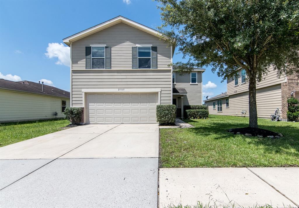 a front view of a house with a yard and a garage