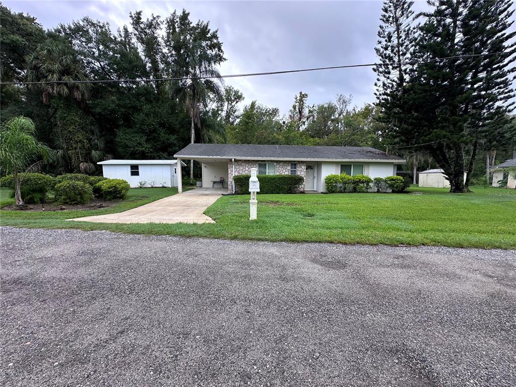 a front view of a house with a yard and trees