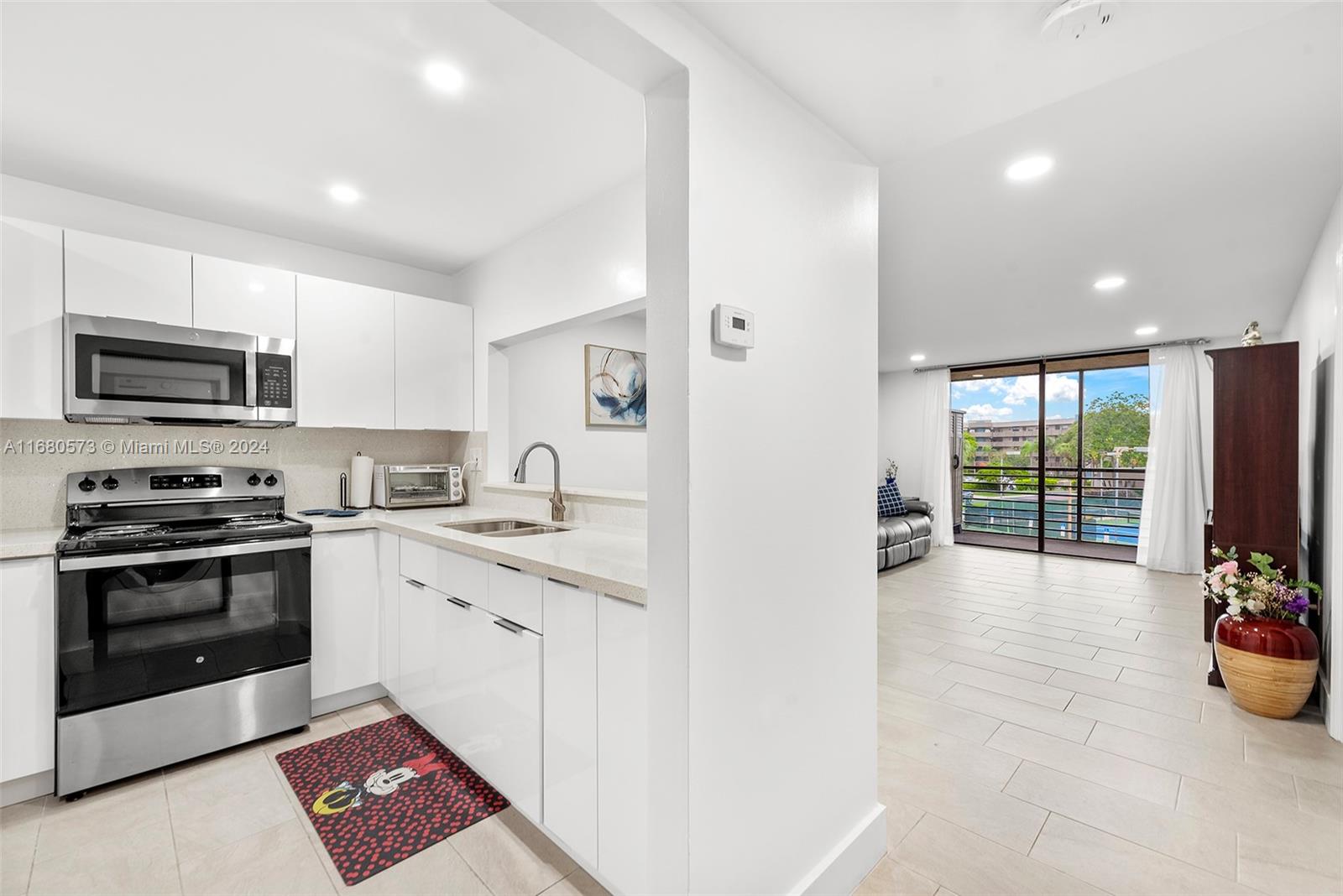 a large white kitchen with a stove a sink and a refrigerator