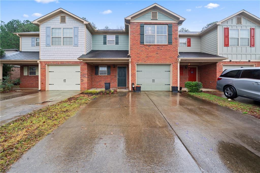 a front view of a house with a yard and parking space