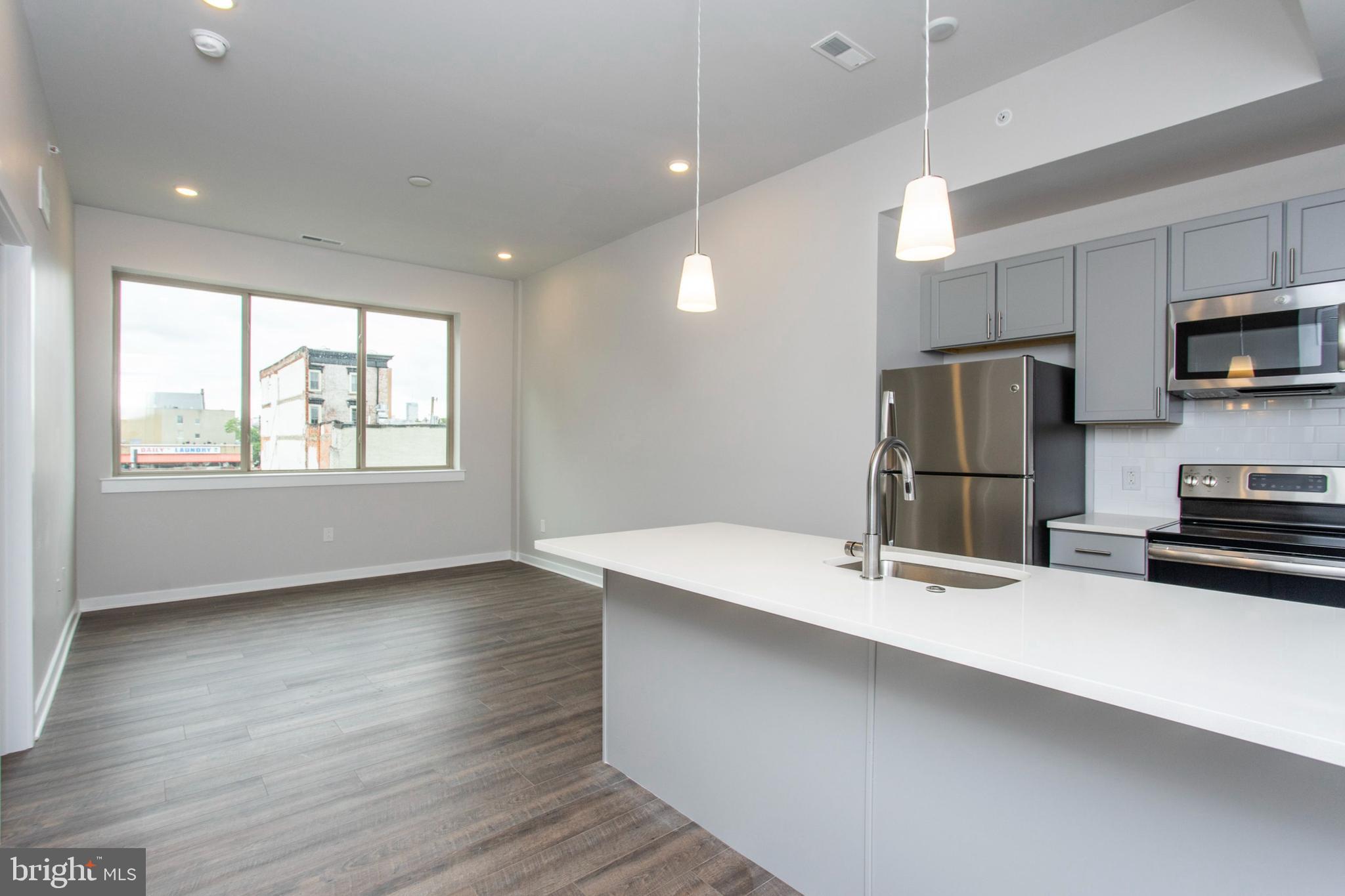 a kitchen with kitchen island a sink appliances and cabinets