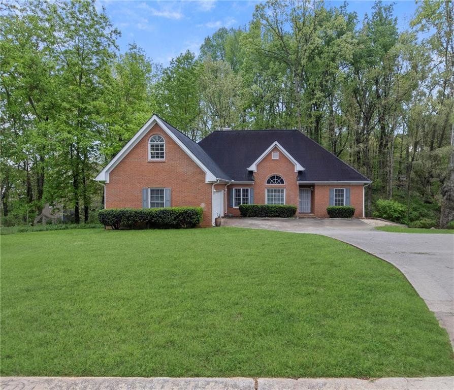 a front view of a house with yard and green space