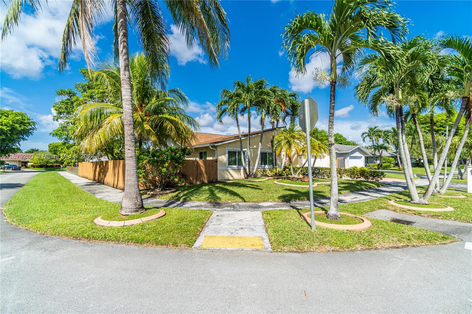 a view of a house with a small yard and palm trees