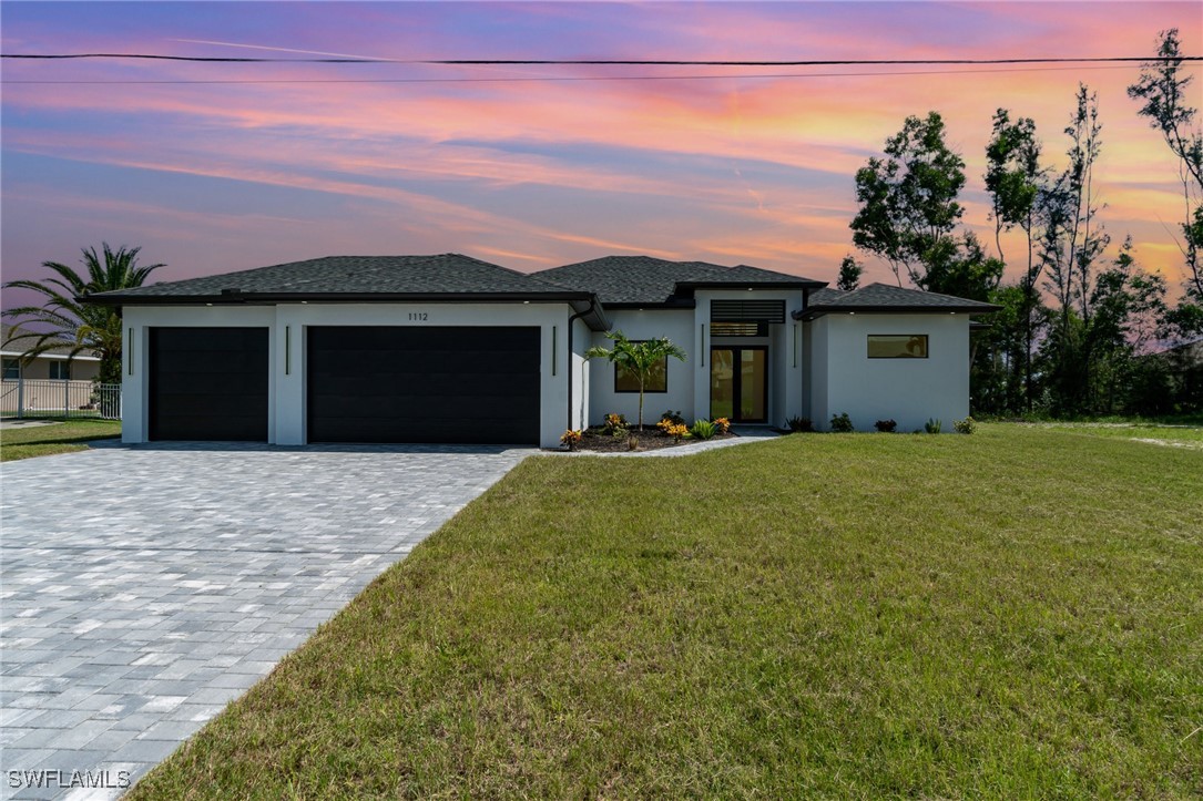 a front view of a house with a yard and garage