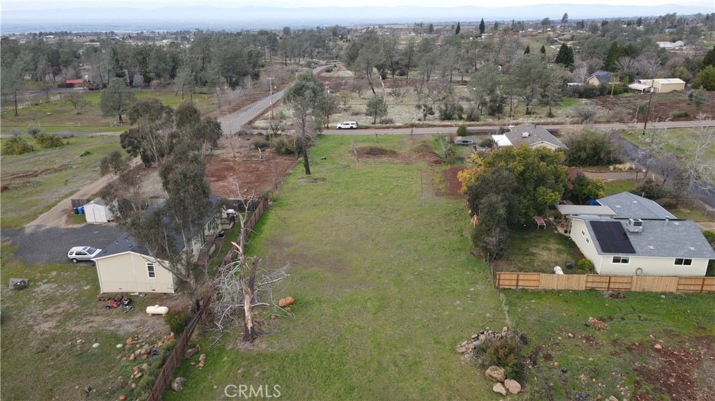 an aerial view of residential houses with outdoor space and trees