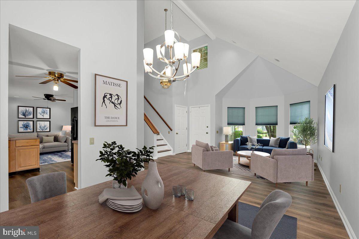 a living room with furniture chandelier and wooden floor