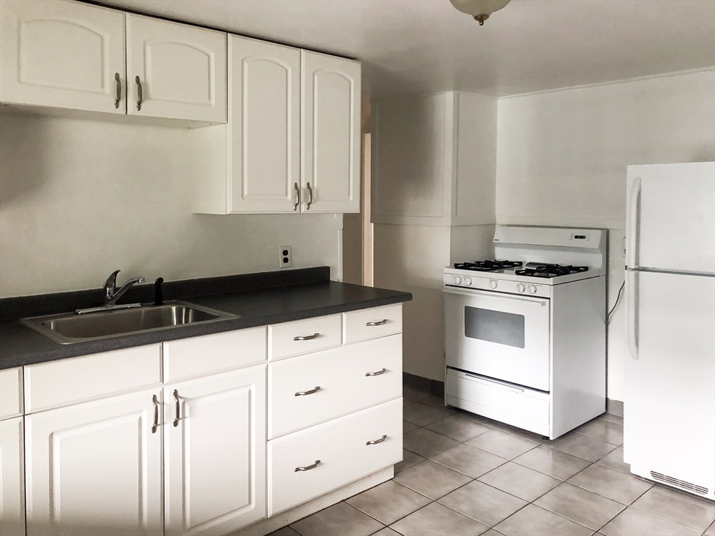 a kitchen with white cabinets and white appliances