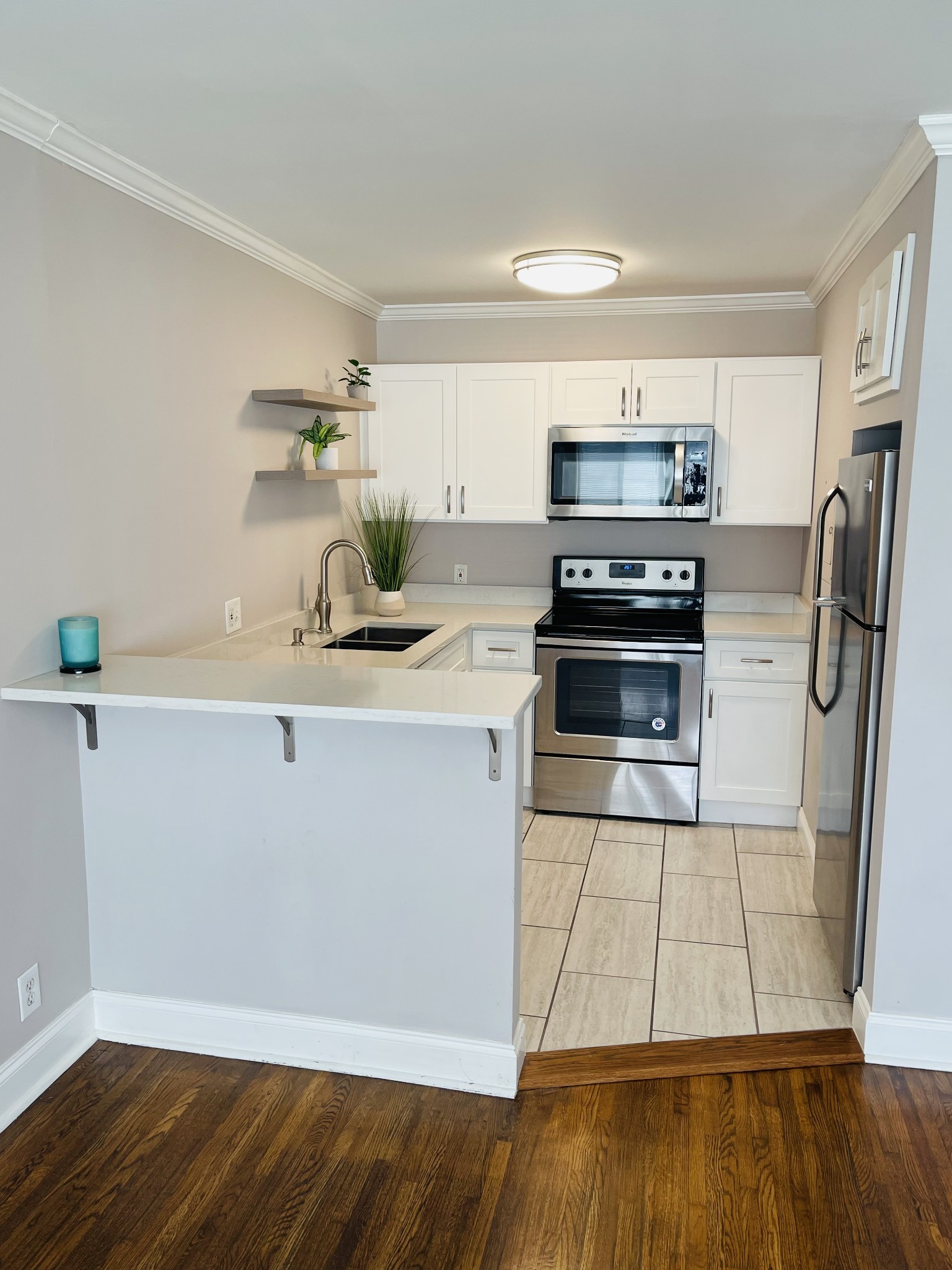 a kitchen with granite countertop a refrigerator and a stove top oven