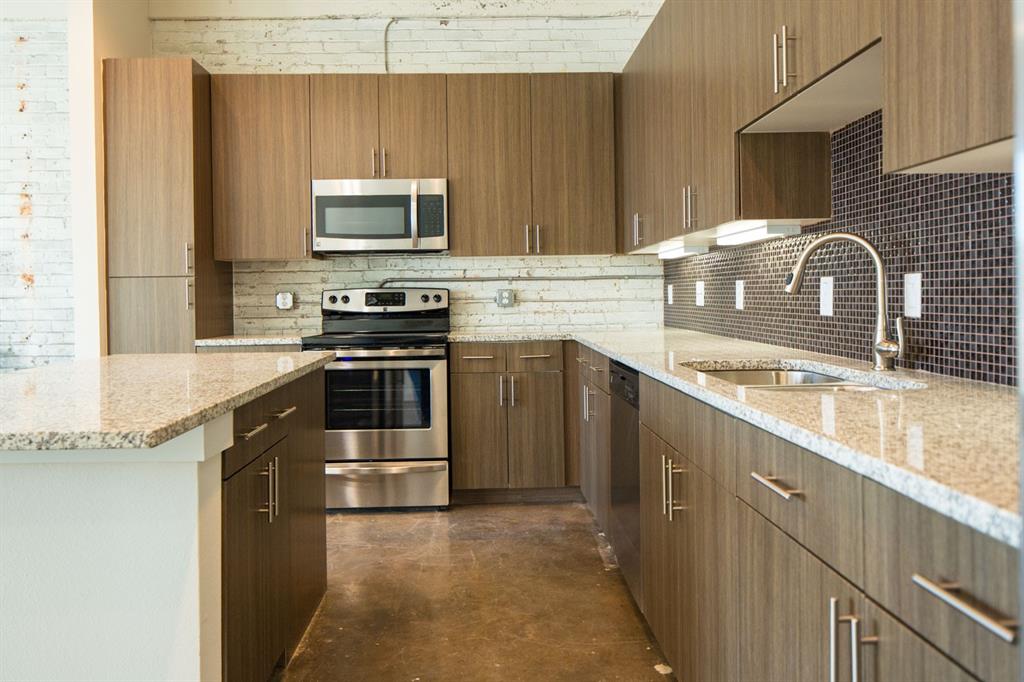 a kitchen with stainless steel appliances granite countertop a sink stove and microwave