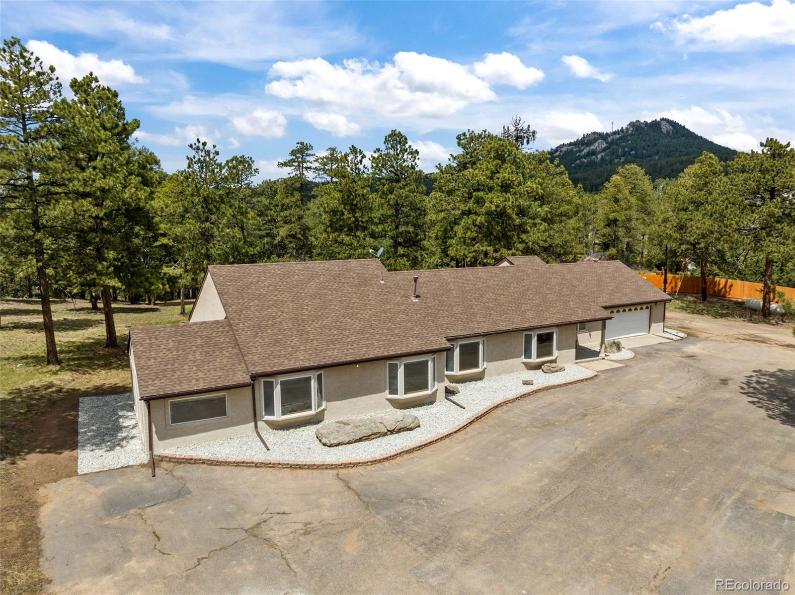 an aerial view of a house with yard and mountain view in back