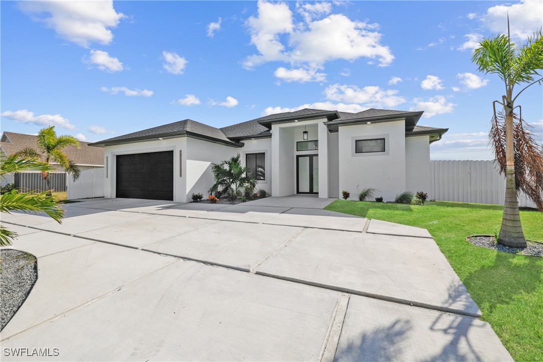 a front view of a house with a yard and a garage