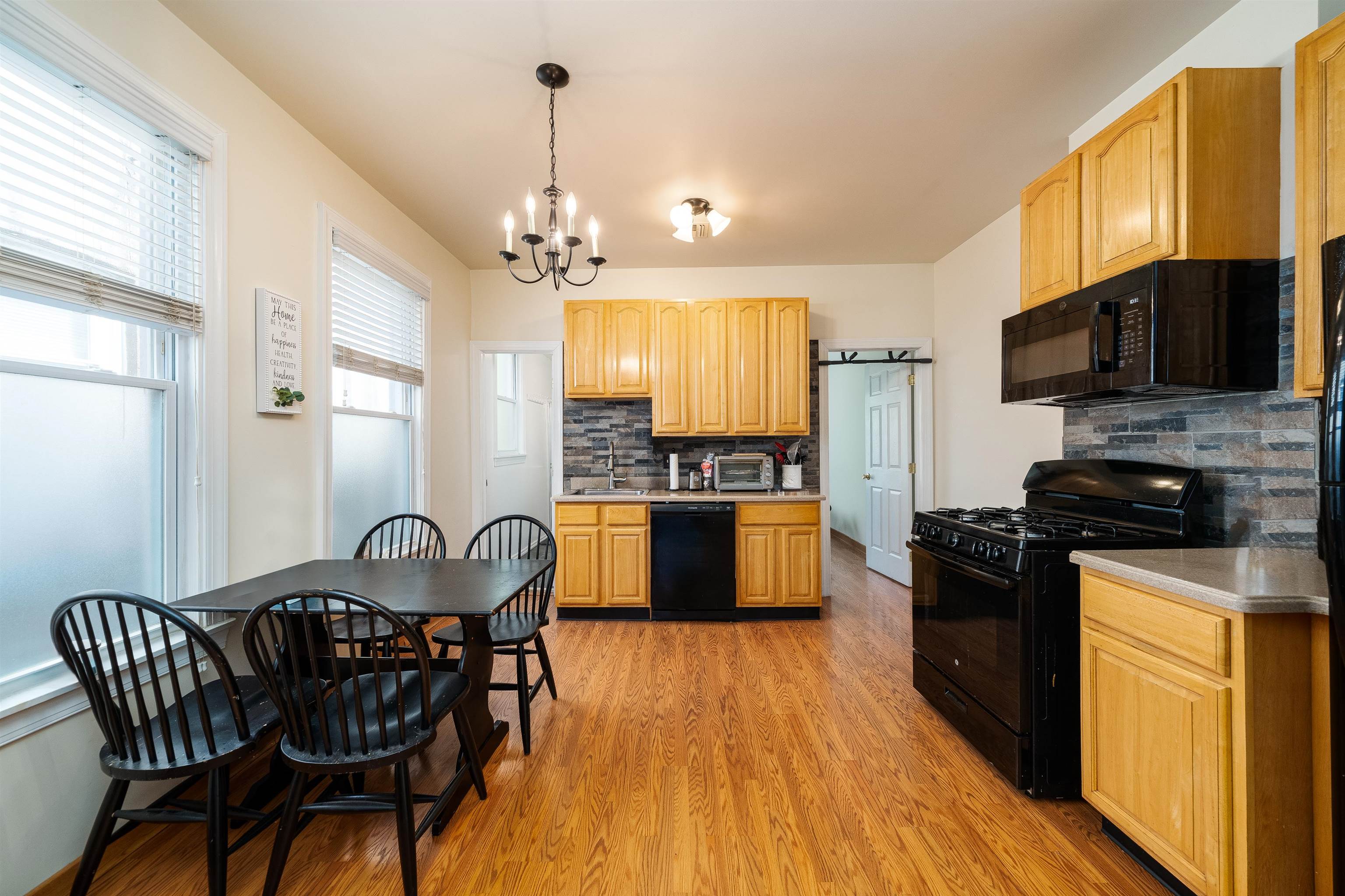 a kitchen with stainless steel appliances granite countertop a kitchen island hardwood floor sink stove dining table and chairs