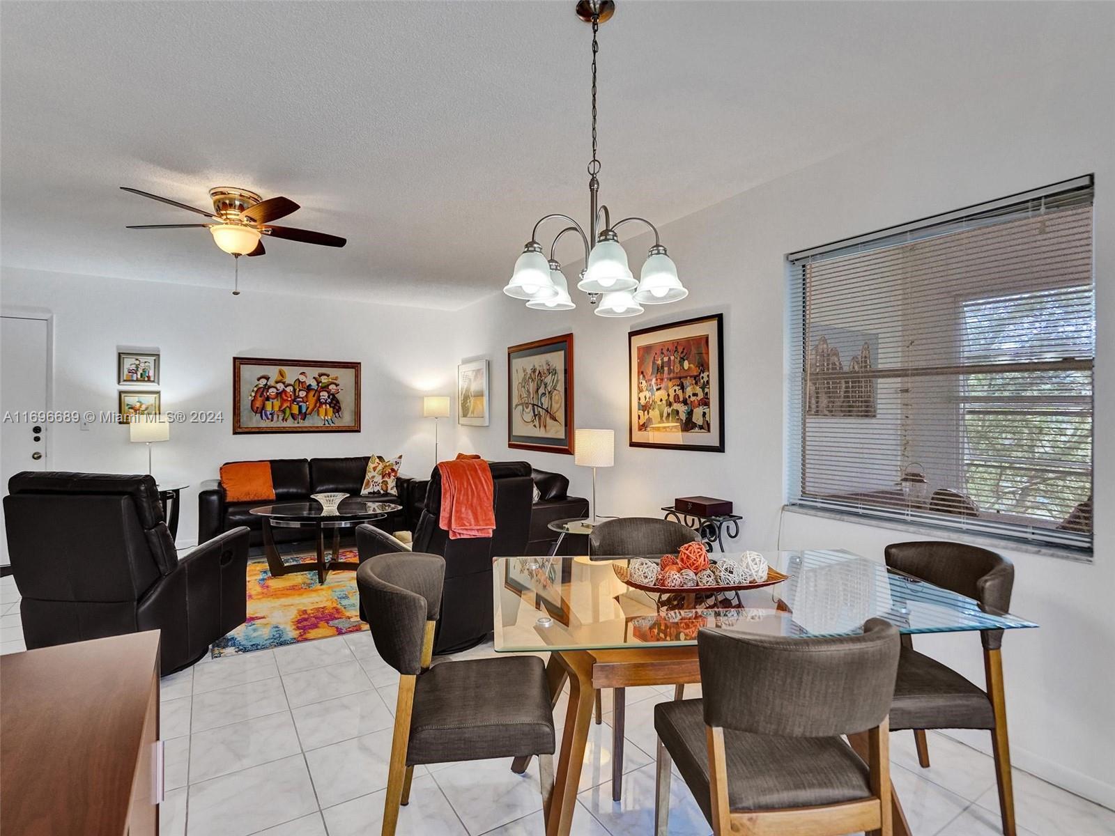 a living room with stainless steel appliances granite countertop furniture and a chandelier