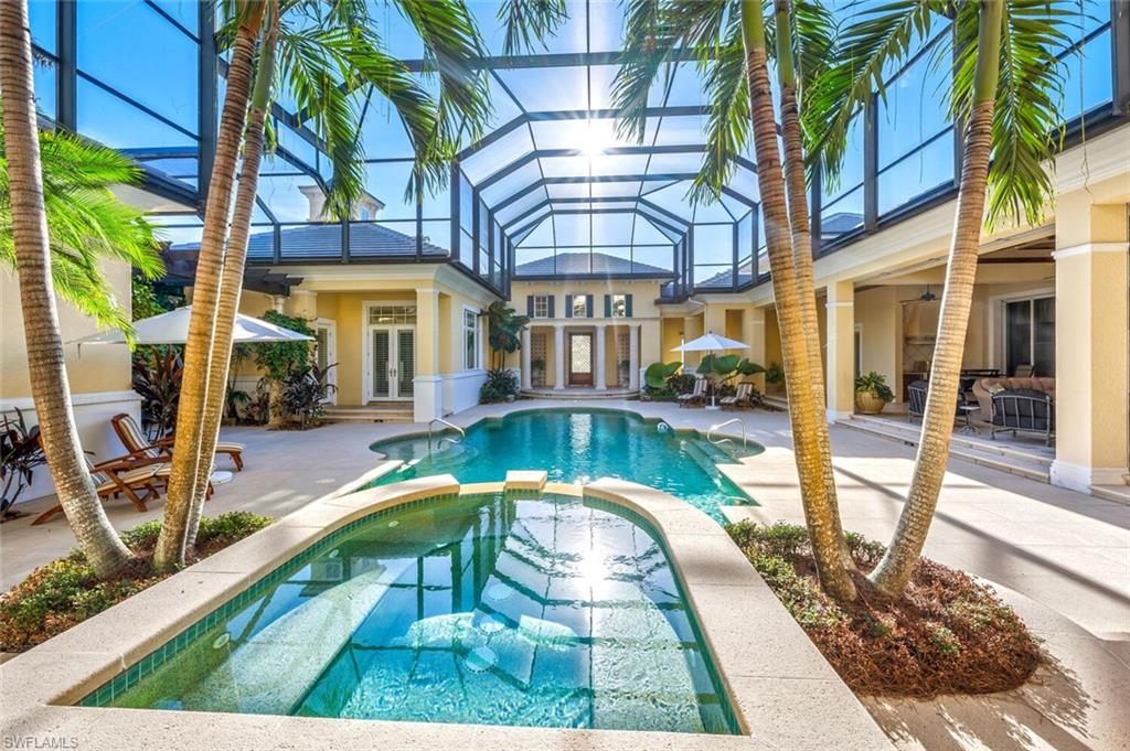 View of swimming pool with screen enclosure, in ground spa, very large patio area for entertaining