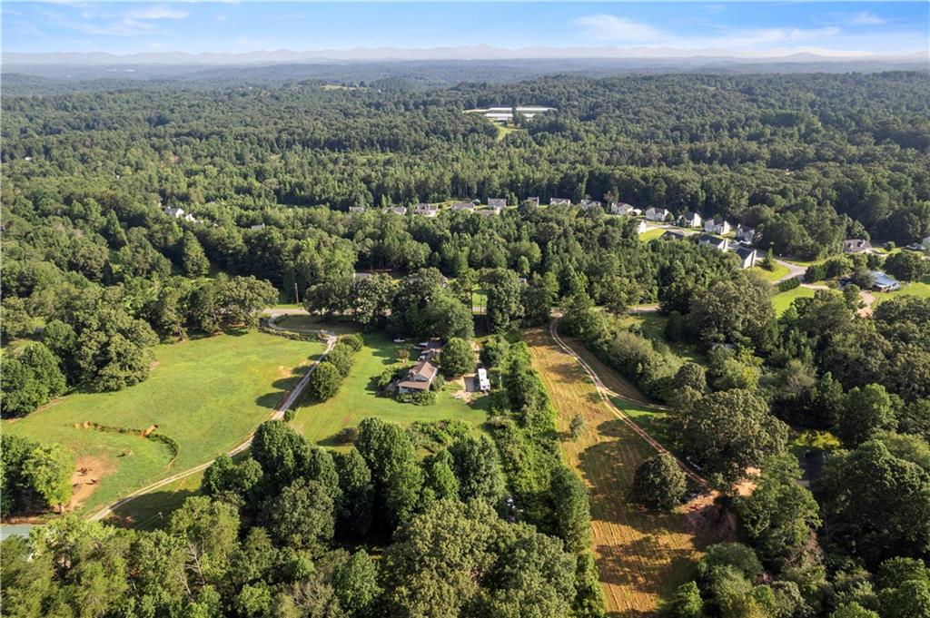 an aerial view of residential houses with outdoor space and trees