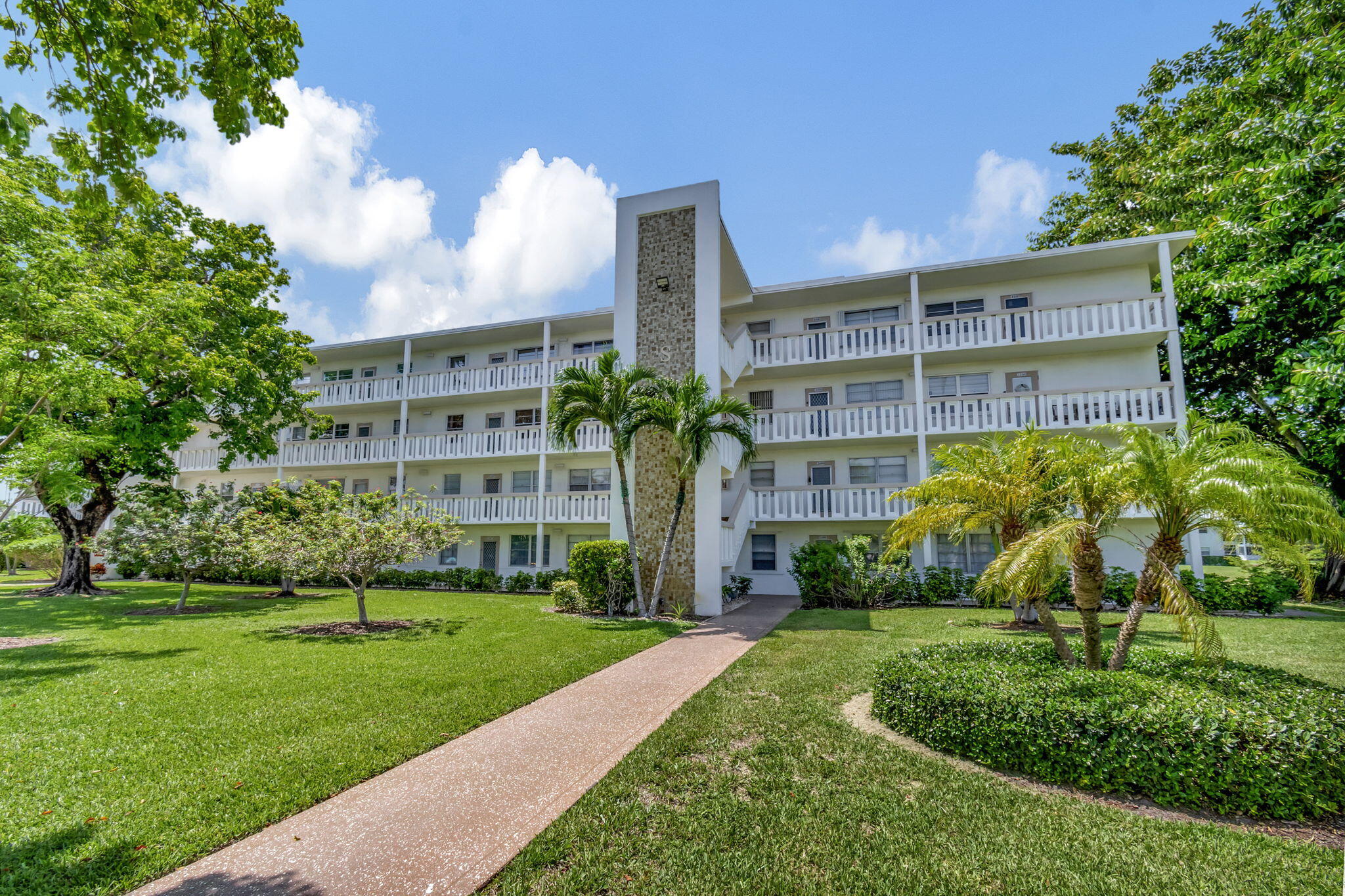 a front view of a multi story building with yard