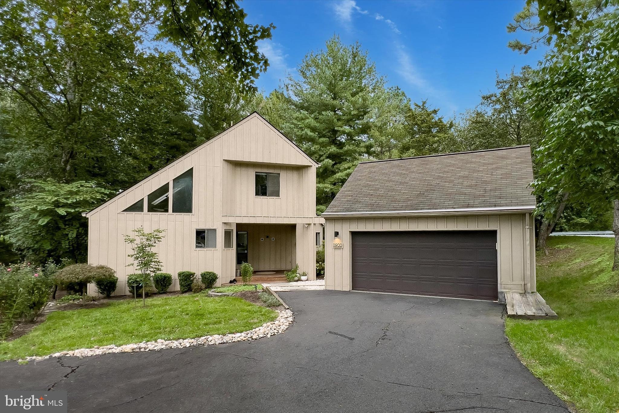 a front view of a house with a garden and garage