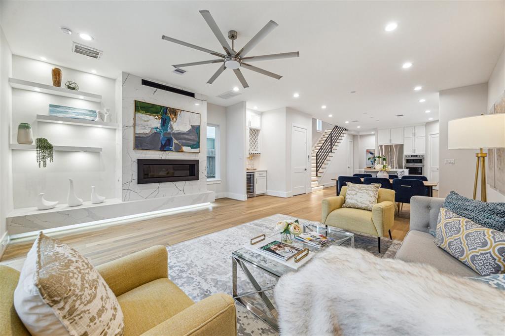 First floor living room with gas fireplace, custom shelving and dedicated bar area with wine/beverage cooler.