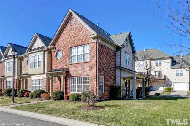 a view of a brick house with a yard