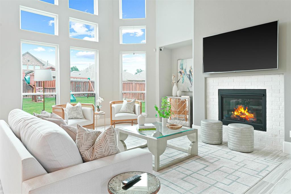 a living room with furniture a fireplace and a flat screen tv