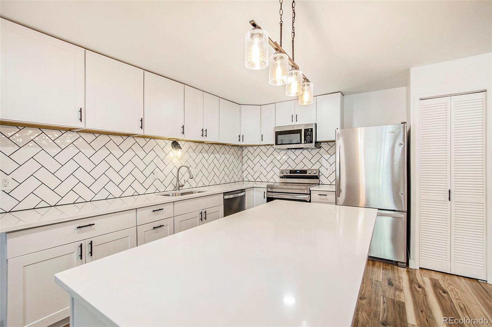 a kitchen with stainless steel appliances a refrigerator sink and microwave